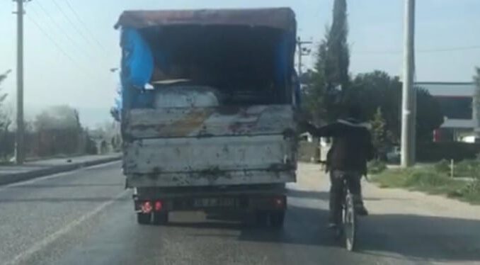 Bursa'da Bisikletiyle Kamyon Kasasına Tutunarak Yolculuk Etti